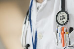 Teil eines Arztkittels mit Stethoskop und Stiften