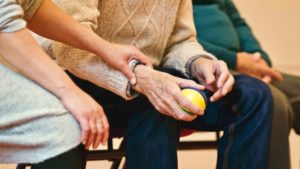 Frau hält die Hand eines älteren Mannes