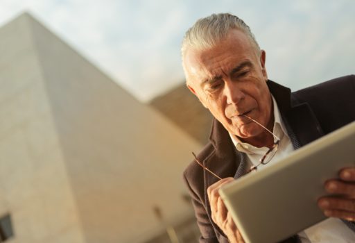 Älterer Mann benutzt ein Tablet.